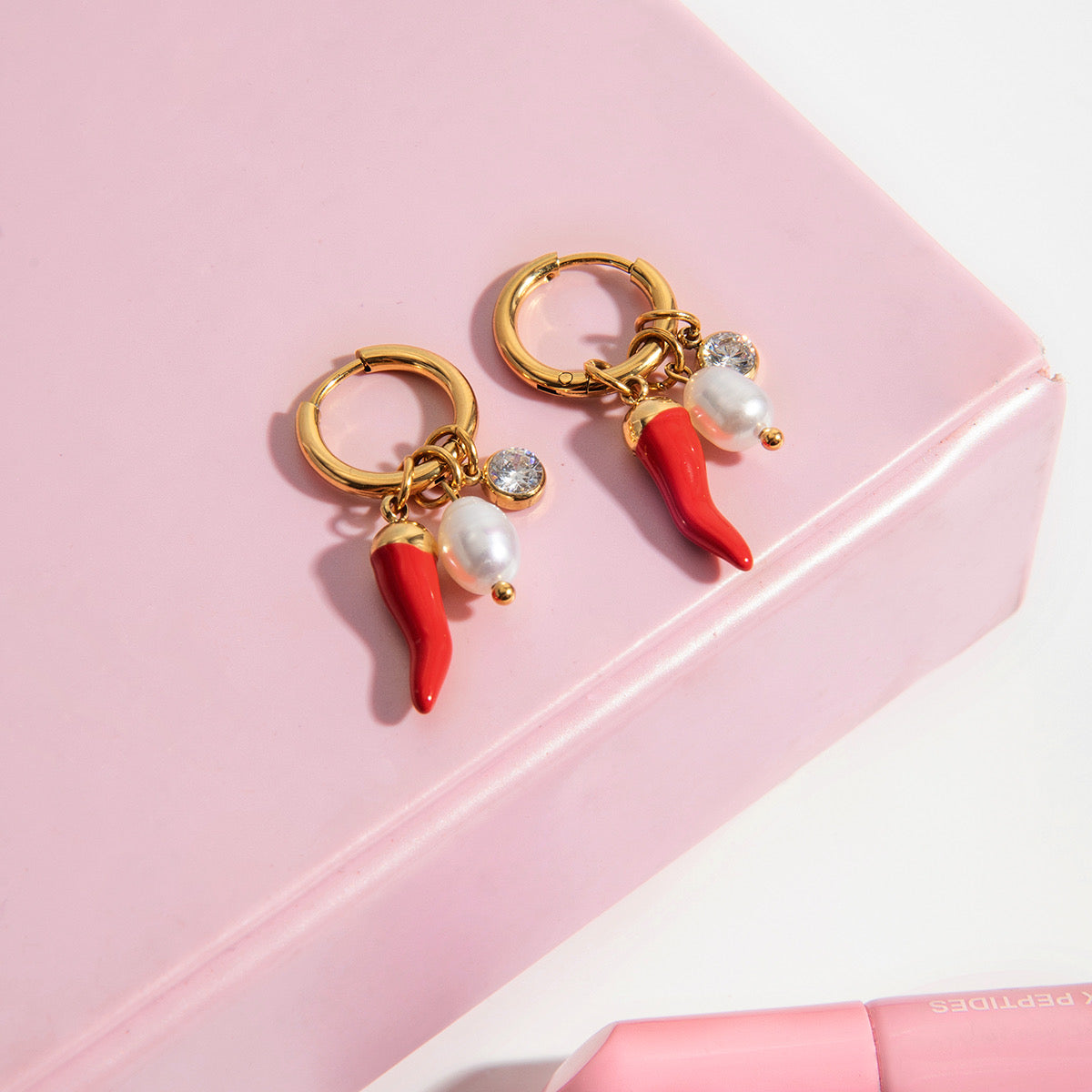 Charm Piment Péi – deux charms piment rouge, perle et strass sur fond rose